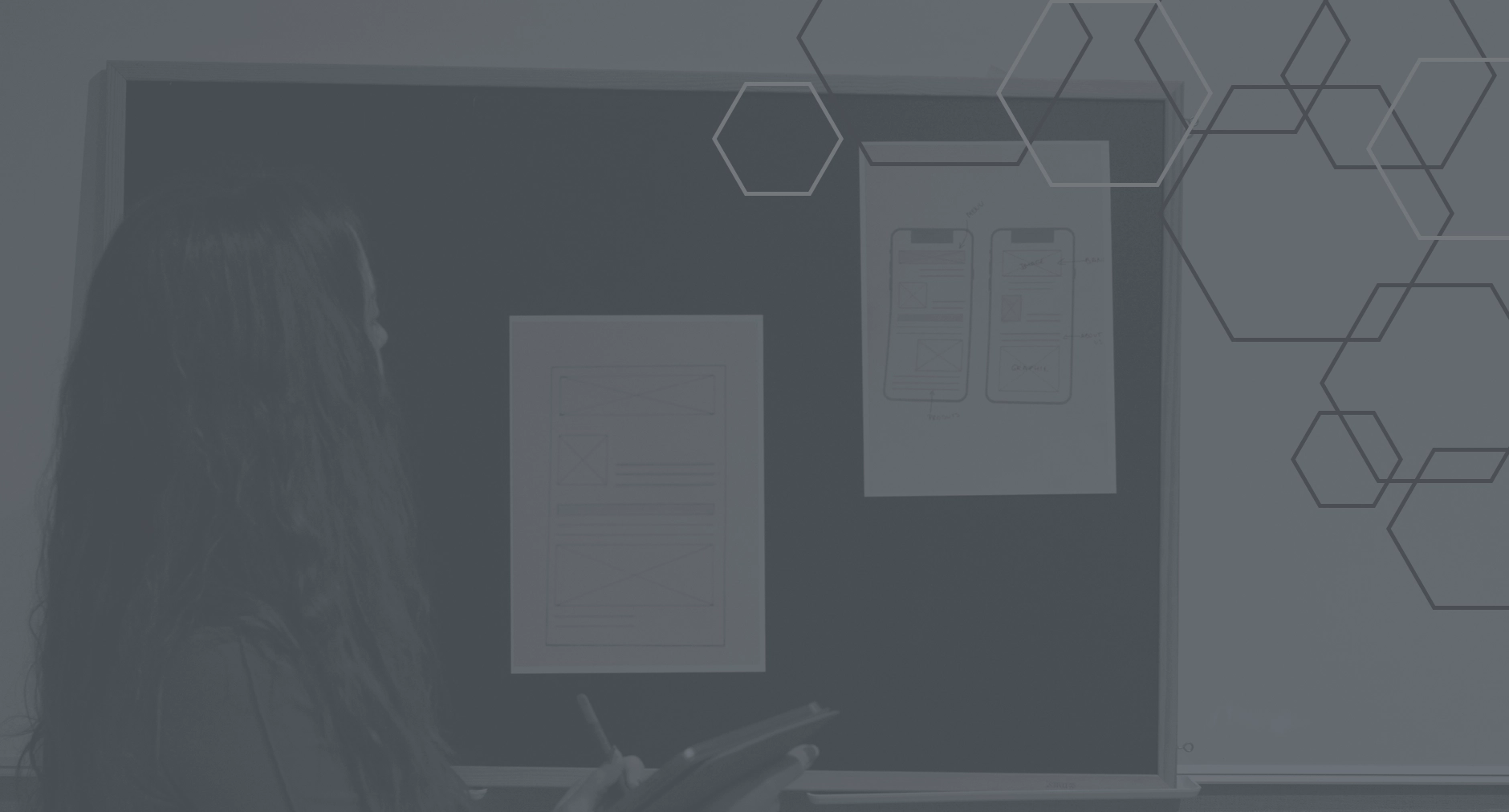 Woman analyzing mobile app wireframes on a board