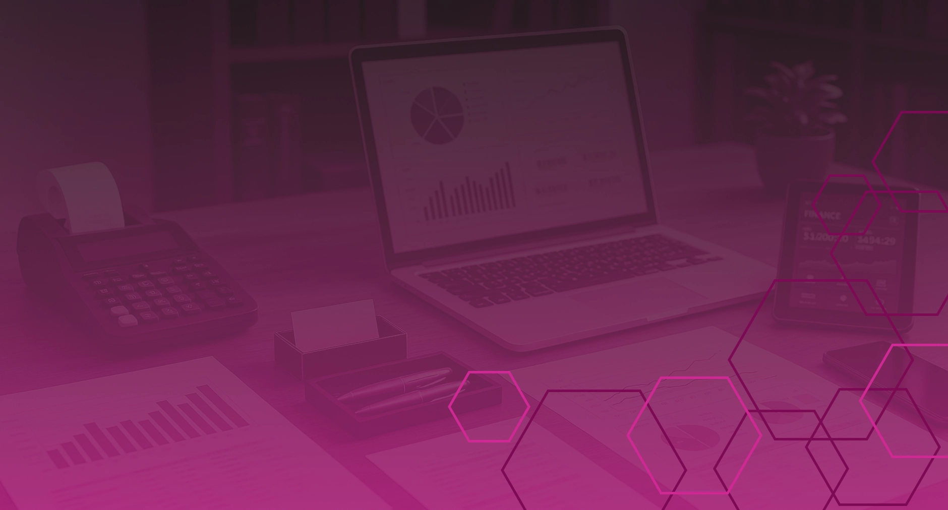 Background image showing financial workspace with laptop and graphs